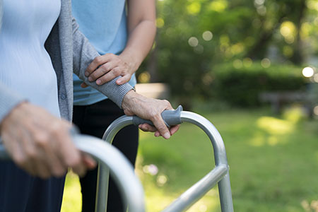 elderly person walking with a walker